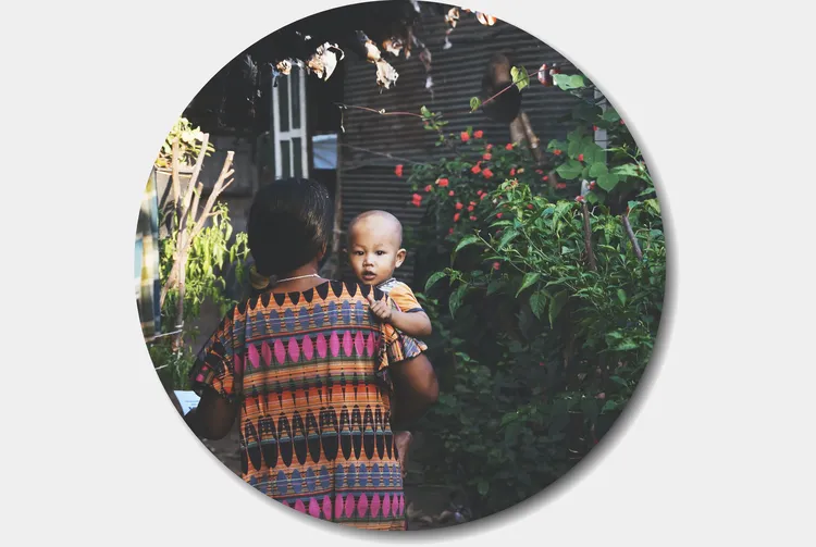 Back view of mother holding child over her shoulder