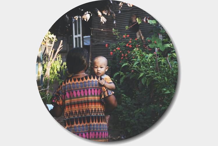 Back view of mother holding child over her shoulder