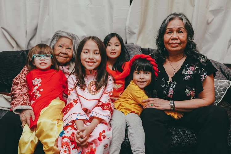 Children on sofa with older female relatives